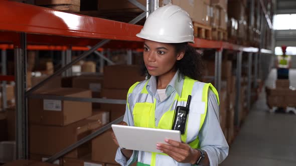 Female with Tablet Taking Inventory in Warehouse