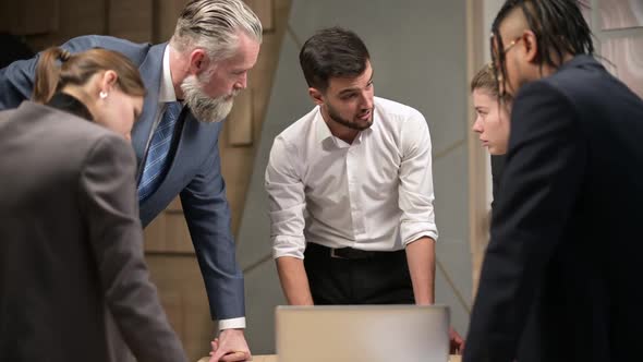 Office workers of different ages and nationalities are amicably discussing work