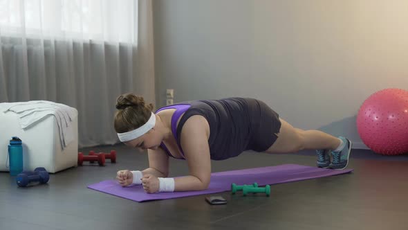 Girl Making Great Effort to Stand in Plank Position, Working Hard to Lose Weight