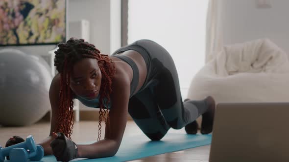 Afro American Woman with Sportswear Stretching Yoga Exercises on Fitness Map