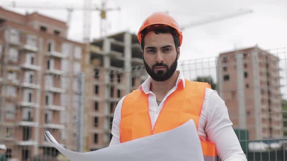 Portrait of Construction Worker in Orange Helmet Looking at the Camera The Builder with