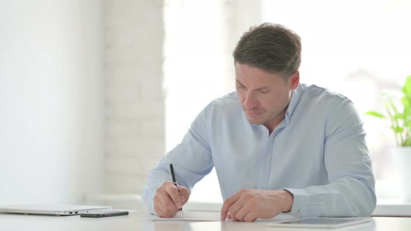 Man having Disappointment while Writing on Paper