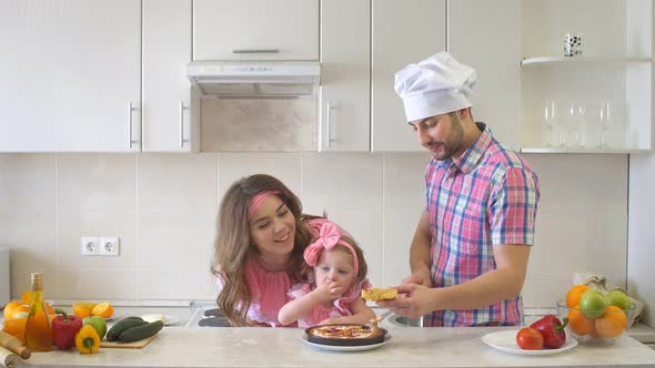 Happy Family In The Kitchen, Dad Cuts The Cake