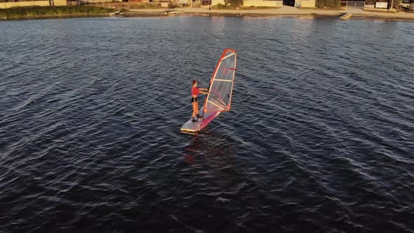 Aerial View of a Sportive Young Woman Learning To Fly a Windsurf Board