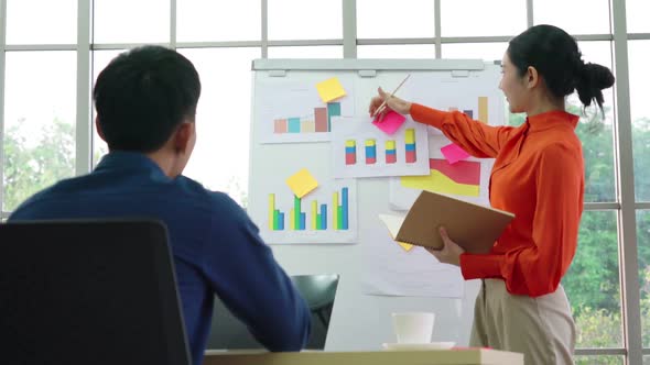 Young Woman Explains Business Data on White Board