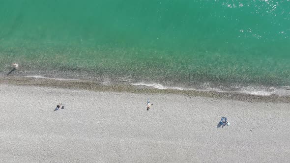 Aerial View of People Crowd Relaxing on Beach and Sea with Waves. Top View From Flying Drone.