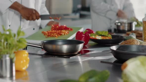 Male Chef Preparing Chopped Bell Pepper in Restaurant Kitchen