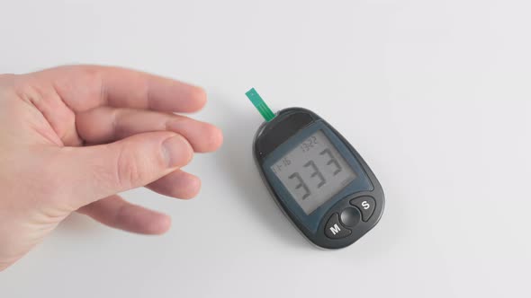 An Unrecognized Man Measures Blood Sugar Glucose, Pierces the Skin of the Finger with a Pen and