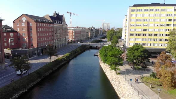 Drone flying over canal in Malmö Sweden. Kronprinsen spotted from far. Late summer, daytime