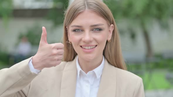 Outdoor Portrait of Young Businesswoman Showing Okay Sign OK