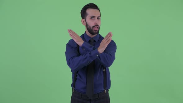 Serious Young Bearded Persian Businessman with Stop Gesture