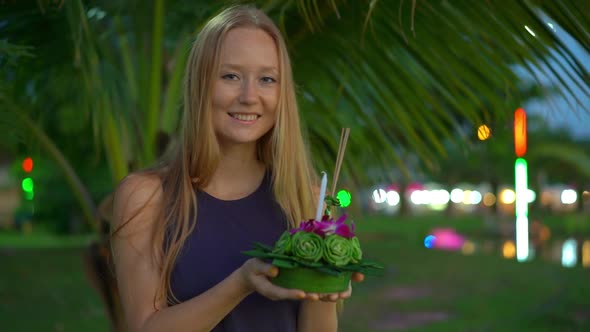 Slowmotion Shot of a Beautiful Young Woman Holding a Krathong in Her Hands Celebrating a Loi