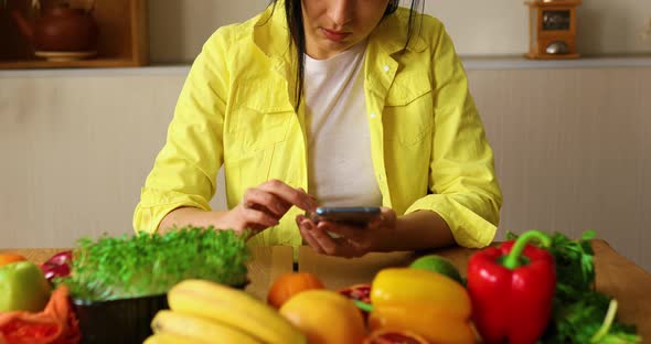 Woman is cooking in the kitchen at home, using digital tablet or smarthone