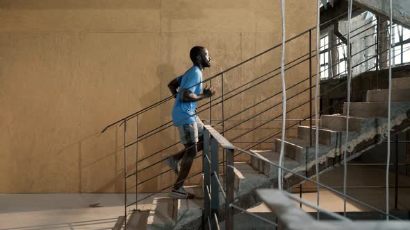 Workout. Runner man running up stairs, training indoors