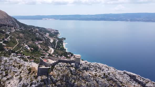 Very nice Drone circle around a castle on a hill over Omis in Croatia