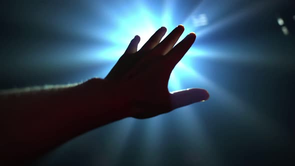 Hand Reaching Out to Cover Shinning Spot Light