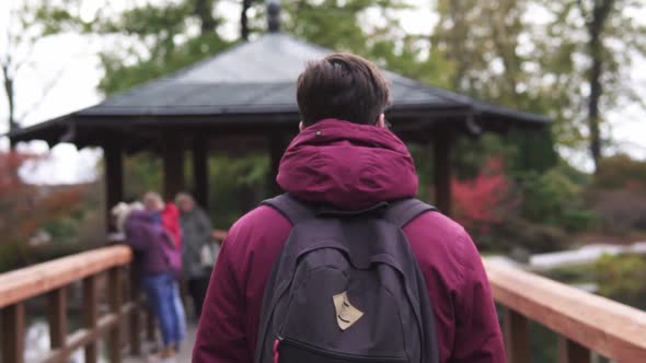 Young tall man walking through a Japanese bridge in Wroclaw