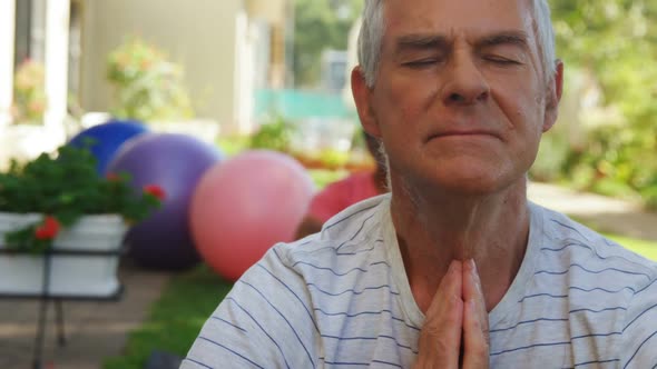 Senior friends performing yoga in garden 4k