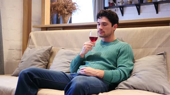 Young Man Drinking Red Wine at Home Relaxing