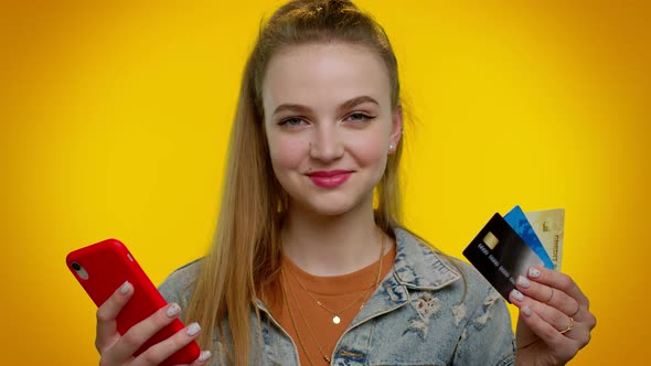 Teen Girl Using Credit Bank Cards and Smartphone While Transferring Money Purchases Online Shopping