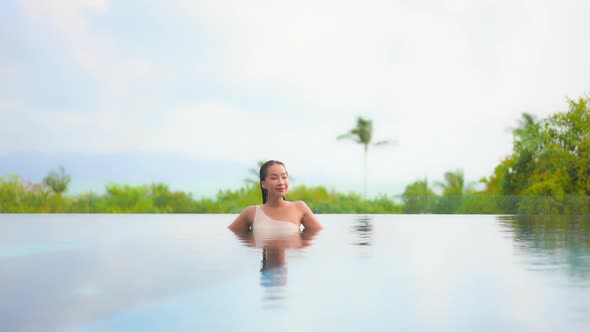 Young asian woman enjoy around outdoor swimming pool for leisure