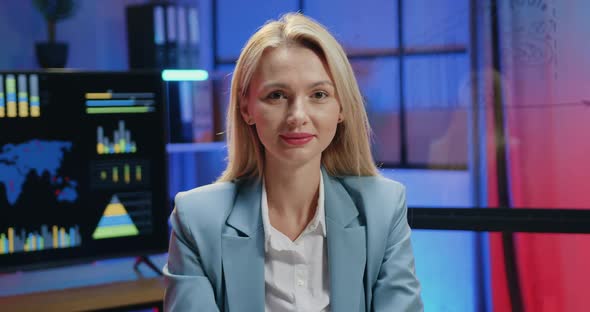 Businesswoman Posing on Camera in Modern Office while Working Overtime in the Evening