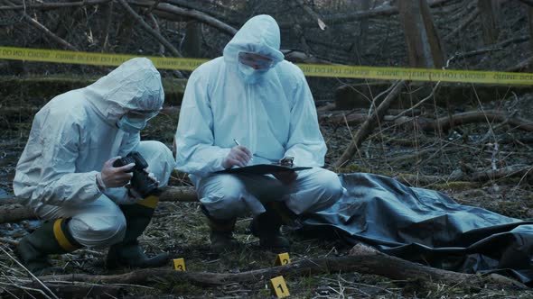 Forensic specialists working in the forest. Crime scene and police concept.