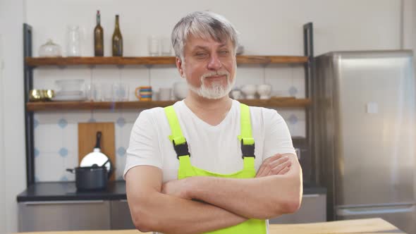 Handsome Aged Plumber with Crossed Arms Looking at Camera n in Kitchen