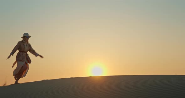 Cheerful Woman Running Barefoot on Sand Dune