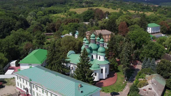 Nice top view of the church. Green domes among the trees. Monastery in the forest.