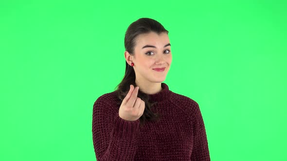 Cute Girl Smiles and Showing Heart with Fingers. Green Screen