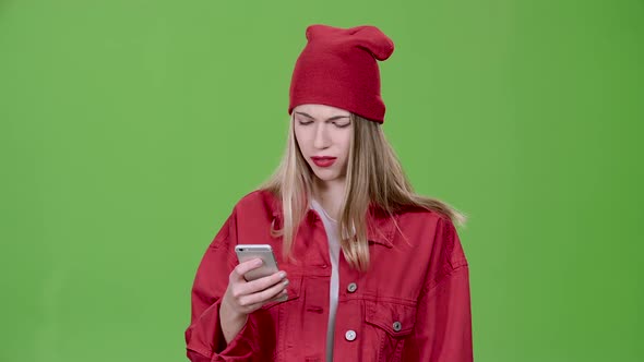 Teenager Looks at the Pictures in the Phone and Shows a Thumbs Up. Green Screen