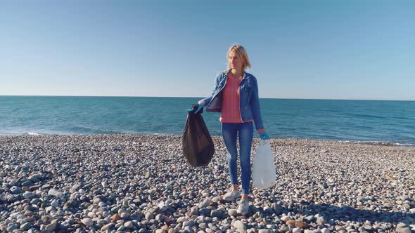 a woman collecting cleaning plastic bottles on the beach,