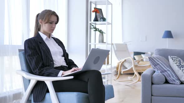 Young Woman Typing On Laptop in Office