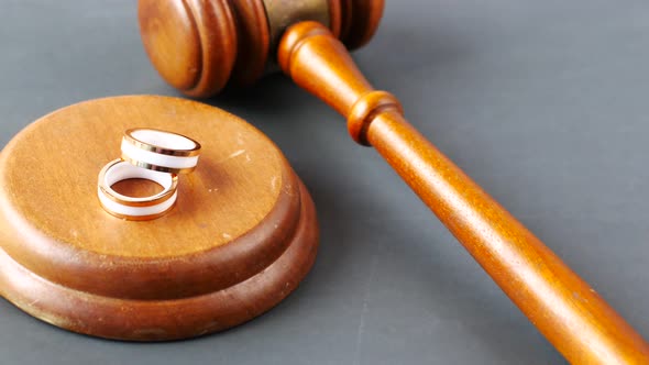 Divorce Concept with Gavel and Wedding Rings on Table