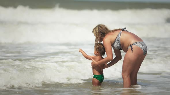 Mom Throws Her Son Up Over the Sea on Summer Vacation Under the Warm Sun