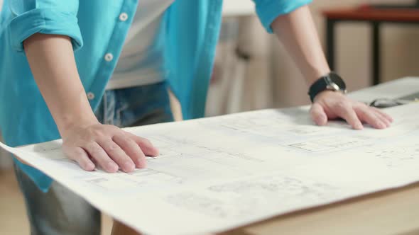 Close Up Of Asian Man Engineer With A Laptop Looking At Blueprint While Working At The Office alt