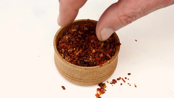 Chef Taking Spices Paprika or Chili Flakes From Wooden Spice Jar