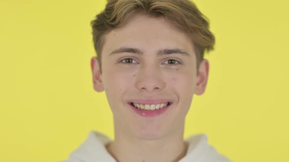 Close Up of Smiling Young Man Yellow Background