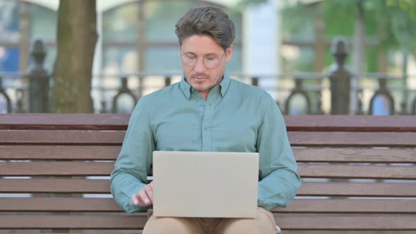 Middle Aged Man Working on Laptop, Outdoor
