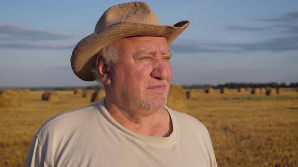 Elderly Caucasian Man Farmer Stands In Rural Field At Sunset
