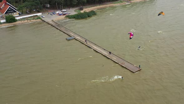 AERIAL: Two Surfers Swimming in the Lake on a Cloudy Day