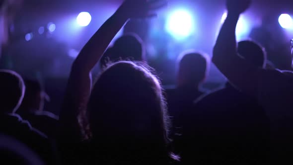 Silhouette of a Girl Dancing at a Rock Band Concert