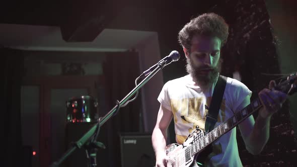 Rock Guitarist with Beard Performs Solo on Stage at the Pub. Rock Music