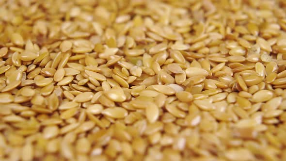 Flax seeds fall in a heap closeup. 