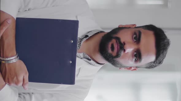 Vertical View of Handsome Young Indian Doctor with Folder