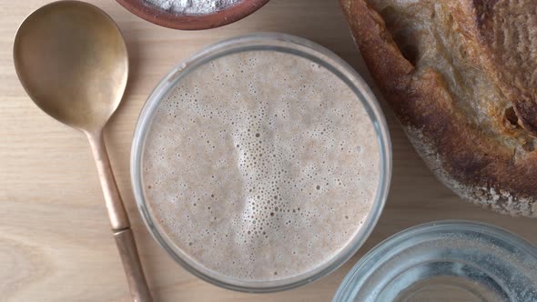 Yeast-free sourdough bread, flour, water and glass jar with dough leaven