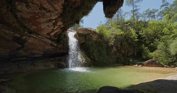 Natural Waterfall and Small Green Lake on Sunny Day