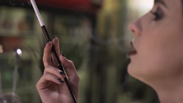 Portrait of a Young Attractive Woman in a 1920s Style Smoke Cigarette at the Bar