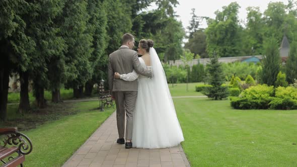 Newlyweds. Caucasian Groom with Bride Walking in Park. Wedding Couple. Man and Woman in Love